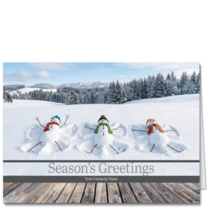 These custom holiday cards for business feature three snowmen who jumped off the wood deck in the foreground to make snow angels in the wintry scene. Your company name and choice of greeting are printed on the front.